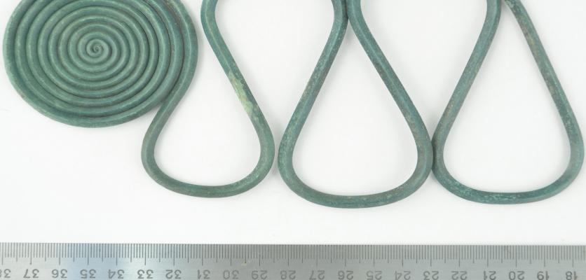 En linjal och en grönfärgad tjock tråd, ett spänne i brons